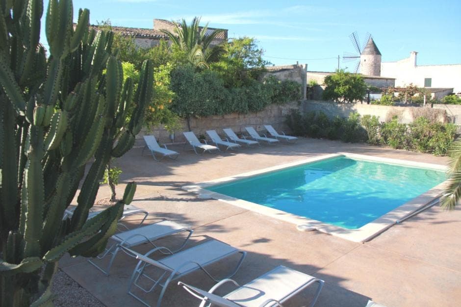 Pool und Garten der Dorfvilla Sa Barcella mit Blick auf die Windmühle von Sineu