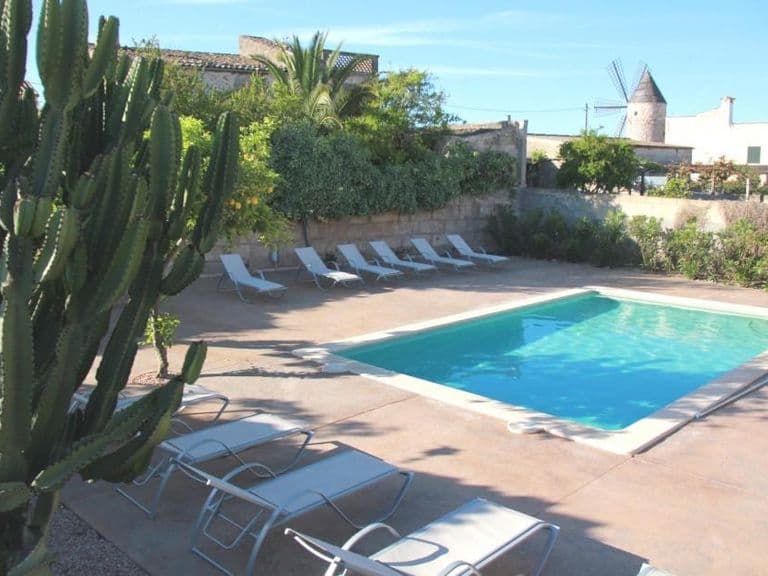 Pool und Garten der Dorfvilla Sa Barcella mit Blick auf die Windmühle von Sineu