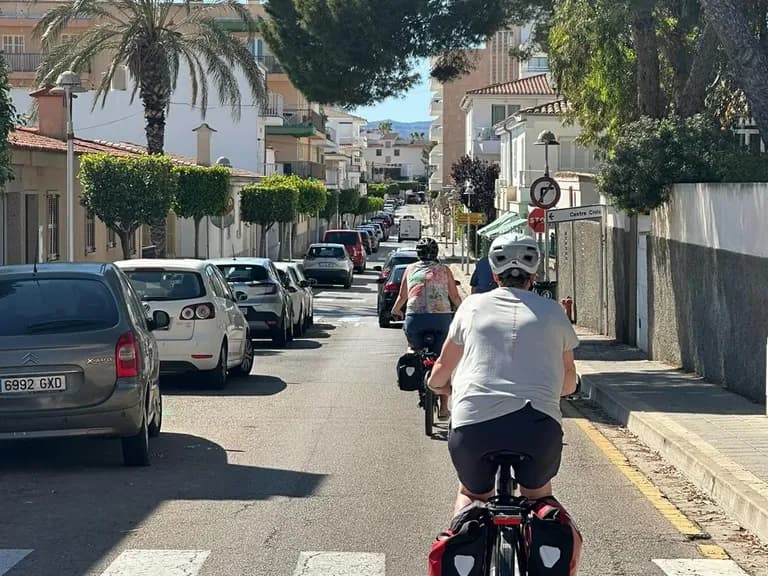 Alcudia Mallorca cycling trip: cyclist riding through the old town towards the sea