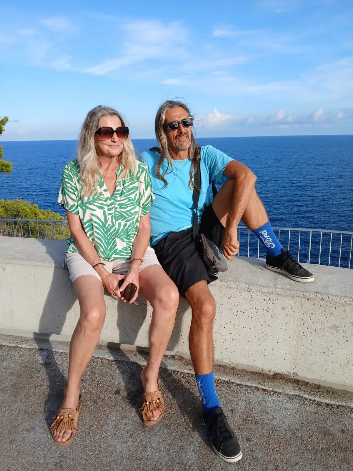 Uli und Stefan von Rad und Finca Mallorca sitzen auf einer Mauer über dem Meer